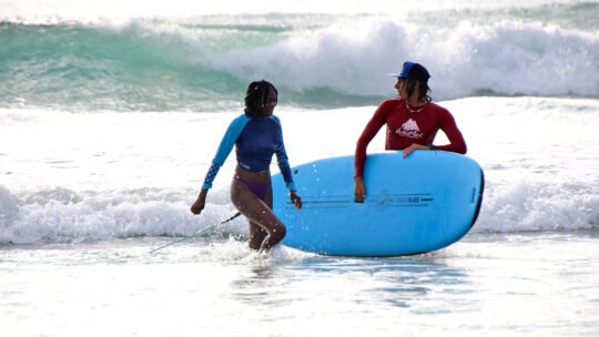 WildMex coach and surfer walking out of the water after a successful lesson