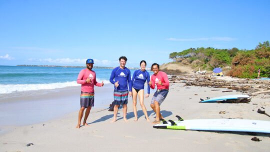 Couple of surfers posing with WildMex instructors at Playa La Lancha