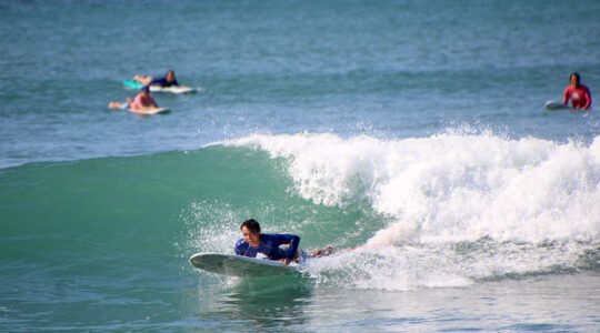 Surfer from WildMex Surf Camp preparing to catch a wave at La Lancha beach