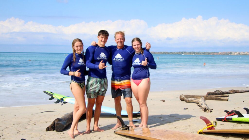 Family hugging with surfboards on the beach in Punta Mita