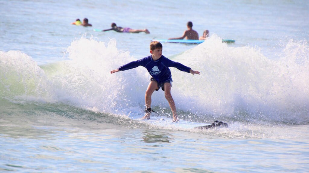 Young boy balancing on surfboard during lesson in Sayulita