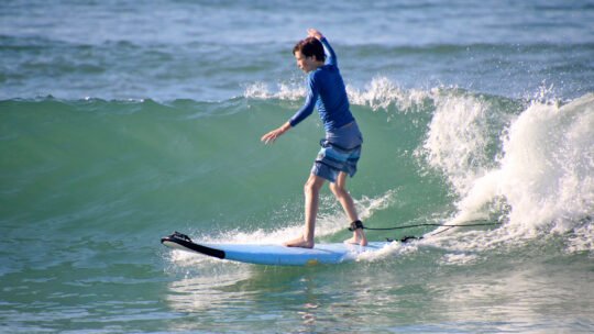 Young boy surfing with deep focus and connection to the ocean in Punta Mita