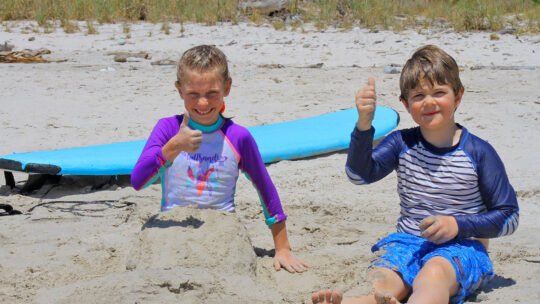 kids playing on the sand after their surf lesson in Punta Mita