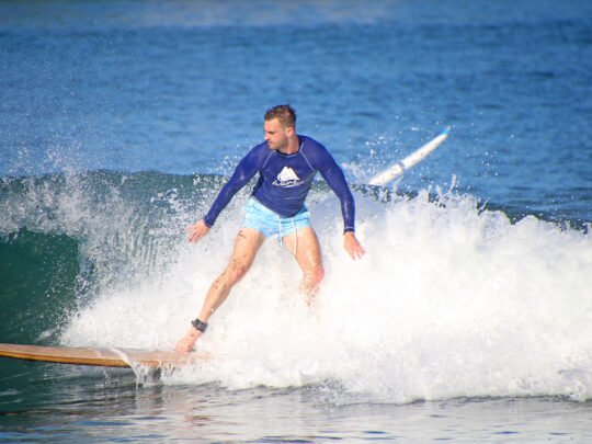 longboarder trimming on a clean right point during surf lessons in sayulita, mexico