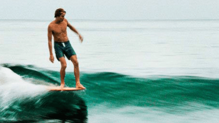 Surf Workout: Enhance Your Performance on the Waves A person practicing yoga on the beach with a surfboard nearby, representing surf fitness and preparation