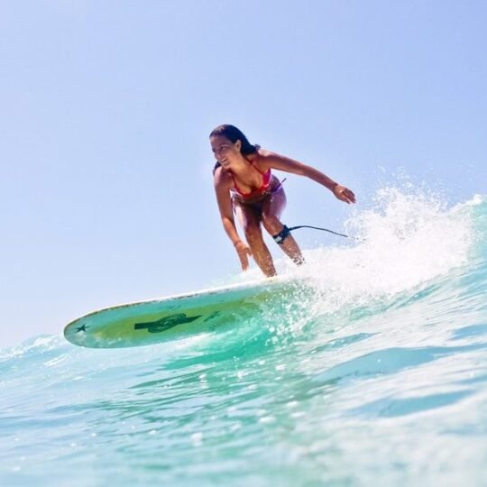 Surfing instructor assisting a surfer with wave selection in Punta Mita