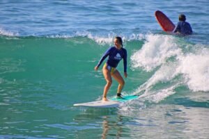Smiling surfer riding a wave during WildMex photo session in Punta Mita
