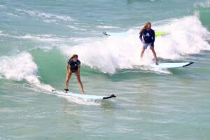 Two friends surfing the same wave during WildMex surf photography session