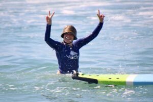 Surfer raising arms in celebration after catching a wave during photo session