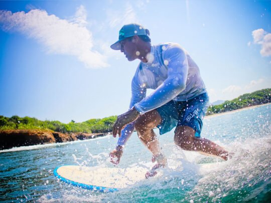 Surfer riding a wave at La Lancha beach during advanced surf coaching session in Punta Mita